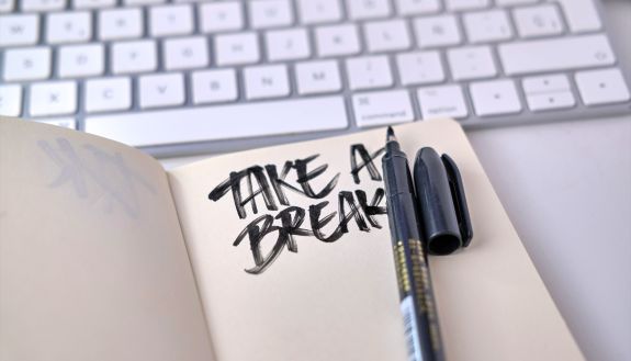 A notebook reads "take a break" next to a computer keyboard